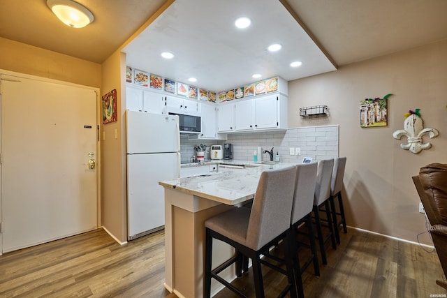 740 Weston Rd Unit A-508, Hot Springs, AR 71913 - kitchen featuring a sink, a peninsula, light wood-style flooring, and white appliances