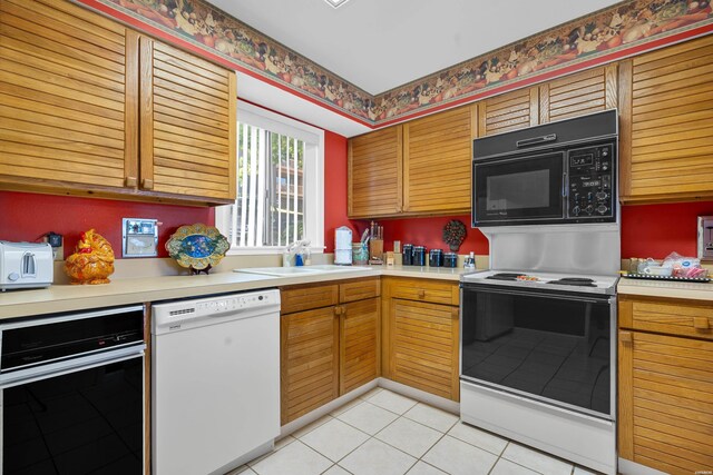 kitchen featuring light countertops, electric range, white dishwasher, a sink, and black microwave