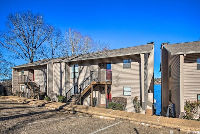 multi unit property featuring stairs and uncovered parking