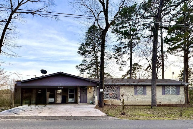 single story home with driveway, a carport, and brick siding