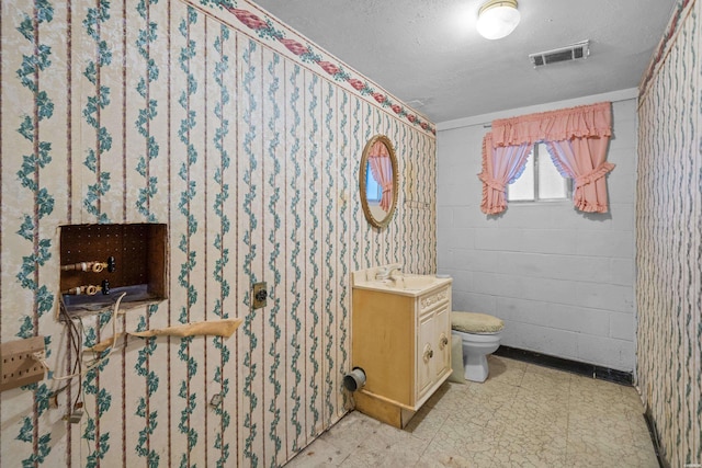 full bath with a textured ceiling, toilet, vanity, visible vents, and tile patterned floors