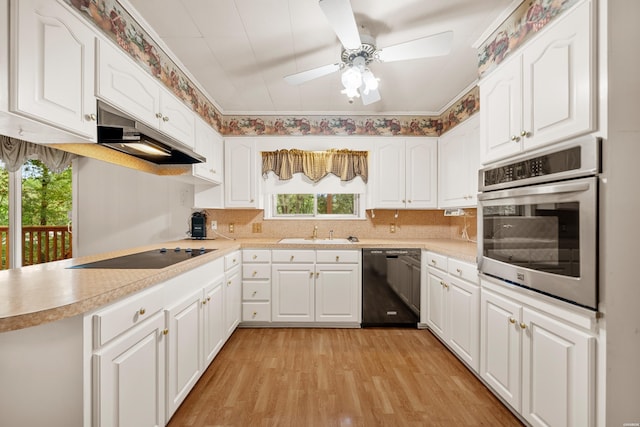 kitchen featuring light countertops, white cabinets, a sink, and black appliances