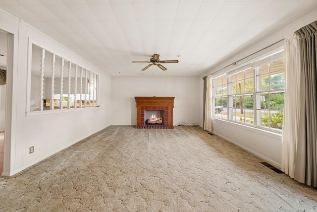 unfurnished living room with visible vents, baseboards, ceiling fan, carpet, and a brick fireplace