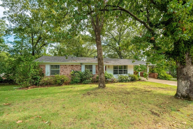 single story home featuring a carport, concrete driveway, a front yard, and brick siding