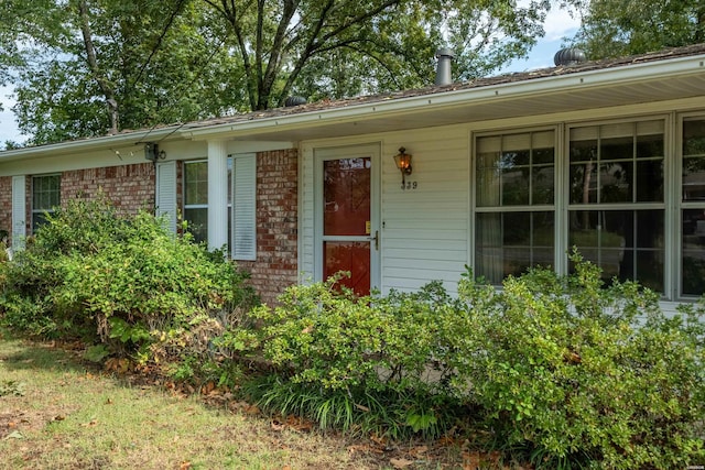 doorway to property with brick siding