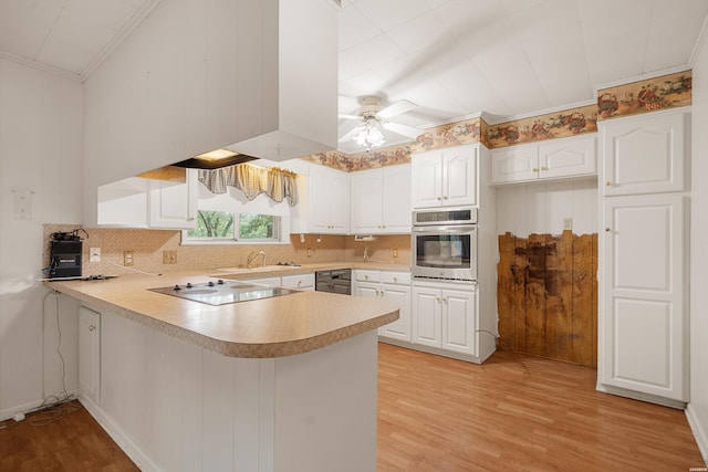 kitchen with white cabinets, black appliances, a peninsula, and light countertops