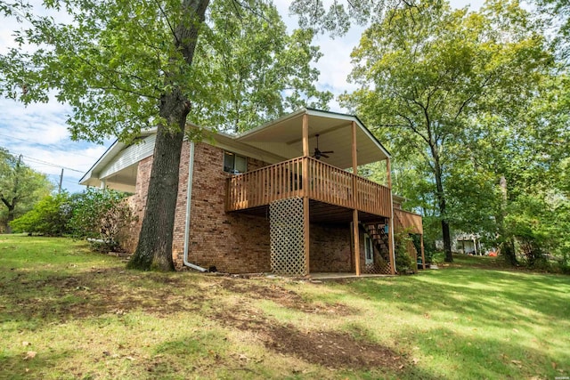 back of house with brick siding, ceiling fan, a lawn, and a wooden deck