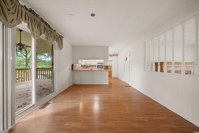 interior space with light wood finished floors, visible vents, and a ceiling fan