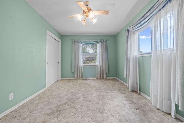 unfurnished bedroom featuring light carpet, a closet, a ceiling fan, and baseboards