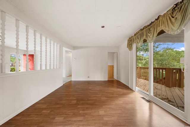 unfurnished room with visible vents and wood finished floors