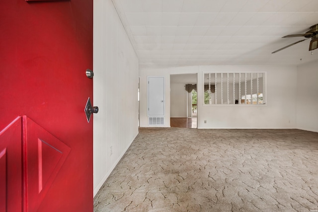 empty room featuring ceiling fan, carpet floors, and visible vents