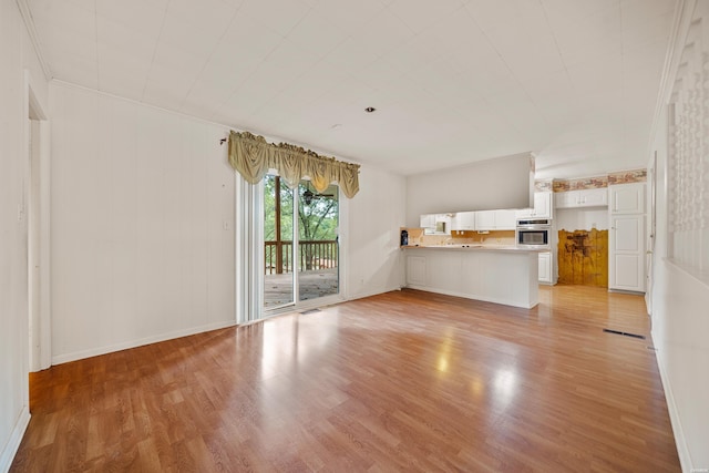 unfurnished living room with light wood-style flooring, visible vents, and baseboards