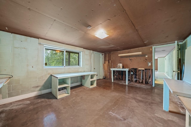 basement with concrete block wall and a workshop area