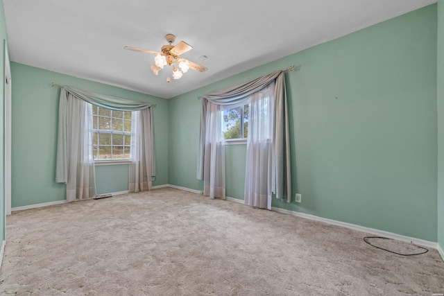 spare room featuring a ceiling fan, carpet, and baseboards