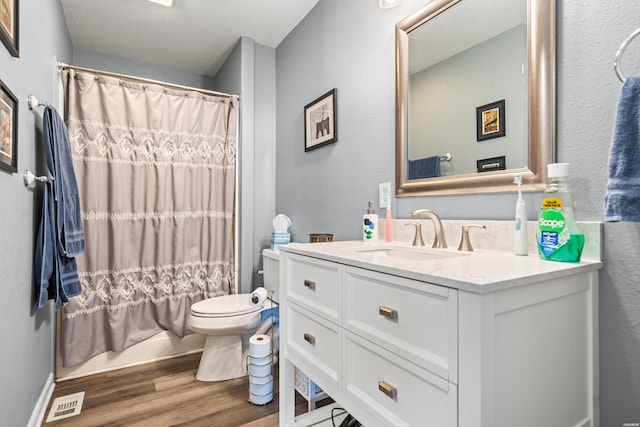 bathroom with toilet, wood finished floors, visible vents, vanity, and shower / bath combination with curtain