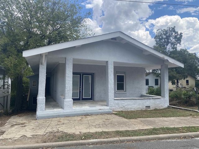 view of front of house with crawl space, a porch, and stucco siding