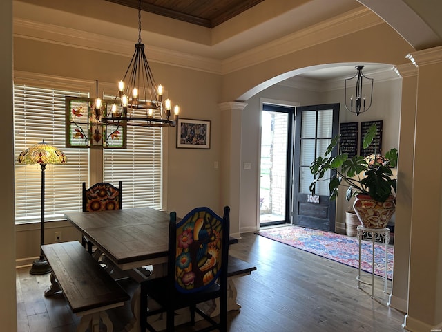 135 Callaway Cir, Hot Springs, AR 71913 - dining area with arched walkways, a chandelier, a tray ceiling, hardwood / wood-style floors, and decorative columns