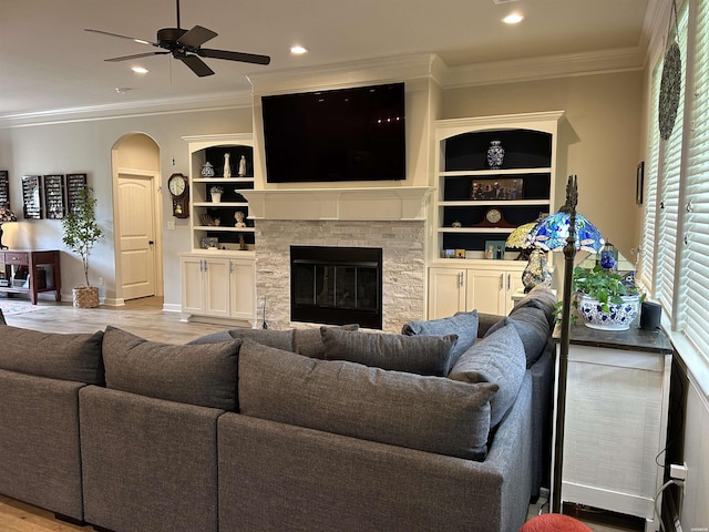 135 Callaway Cir, Hot Springs, AR 71913 - living room featuring arched walkways, ornamental molding, built in features, ceiling fan, and a stone fireplace