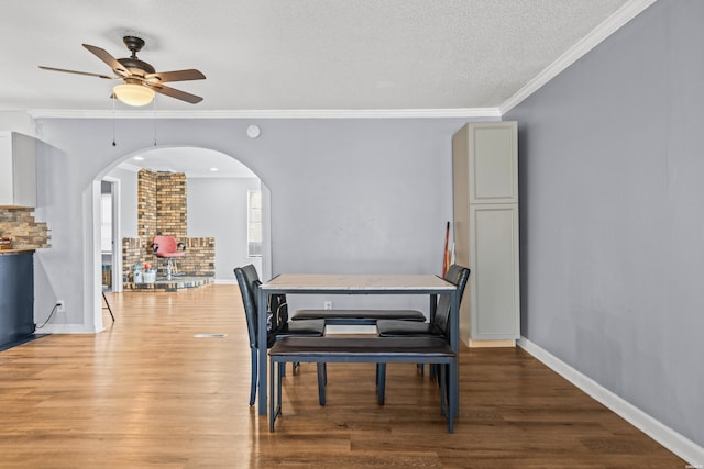 dining room with crown molding, baseboards, and wood finished floors