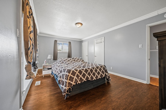 bedroom featuring baseboards, crown molding, visible vents, and wood finished floors