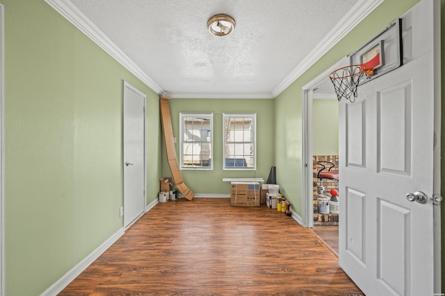 rec room with baseboards, a textured ceiling, dark wood finished floors, and crown molding