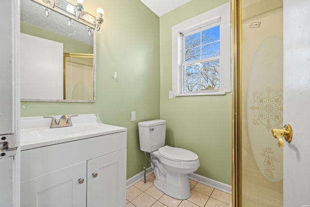 bathroom with tile patterned flooring, toilet, vanity, baseboards, and an enclosed shower