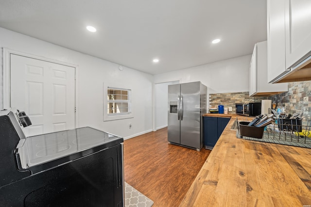 kitchen featuring black microwave, wooden counters, electric stove, backsplash, and stainless steel fridge with ice dispenser