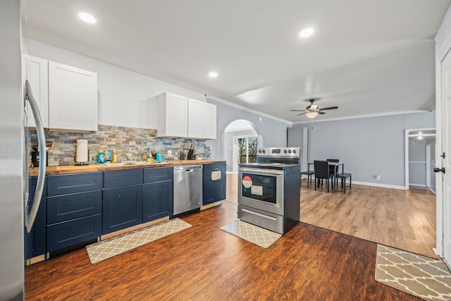 kitchen featuring tasteful backsplash, white cabinetry, stainless steel appliances, and dark wood-type flooring