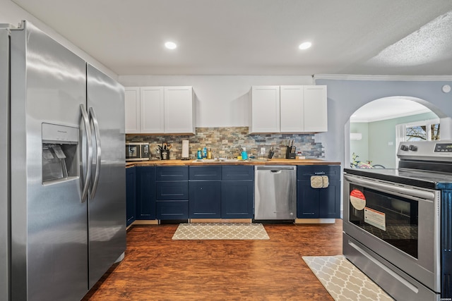 kitchen featuring dark wood-type flooring, butcher block counters, white cabinetry, appliances with stainless steel finishes, and tasteful backsplash