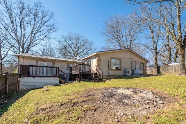 rear view of property with metal roof, a fenced backyard, a yard, and a deck