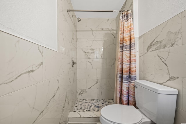 full bathroom with a textured wall, a shower stall, toilet, and tile walls