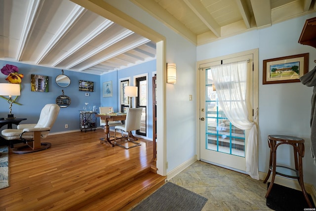 foyer entrance with beamed ceiling, light wood-type flooring, and baseboards