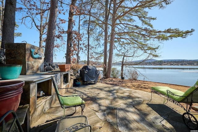 view of patio with a water view and grilling area