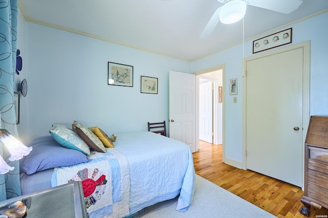 bedroom with ornamental molding, ceiling fan, and wood finished floors