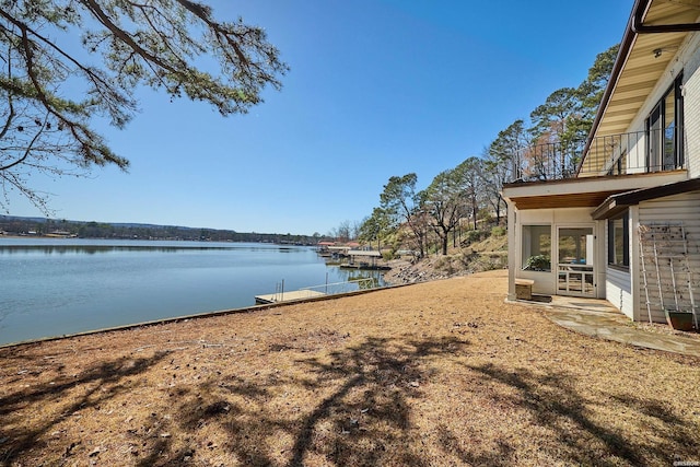 view of yard featuring a water view and a balcony