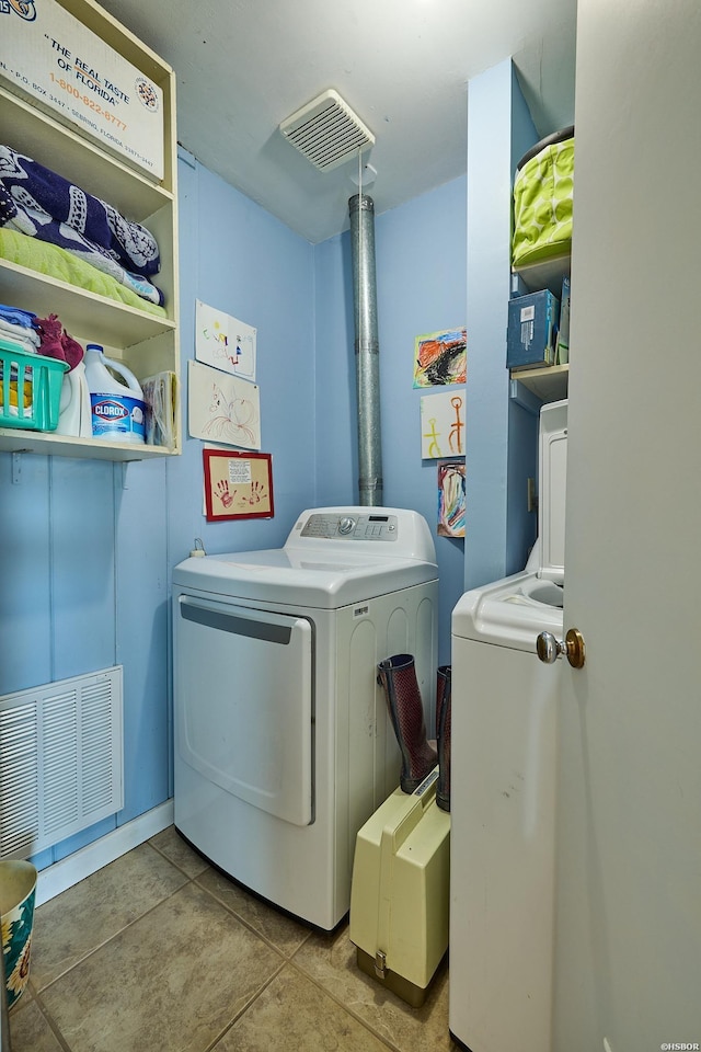 washroom featuring light tile patterned floors, laundry area, visible vents, and washer and dryer