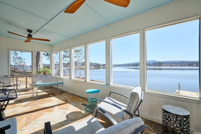 sunroom / solarium featuring a water view and a ceiling fan