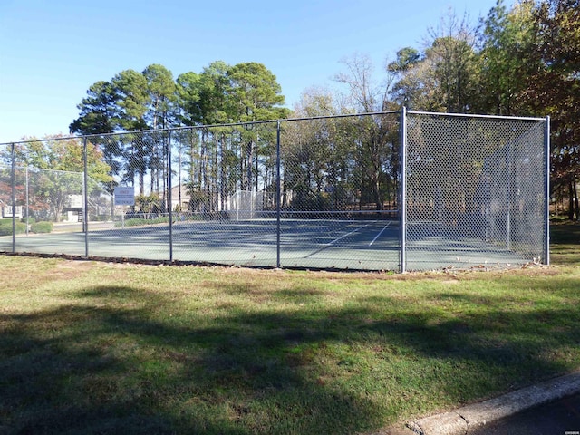 view of sport court featuring a yard and fence