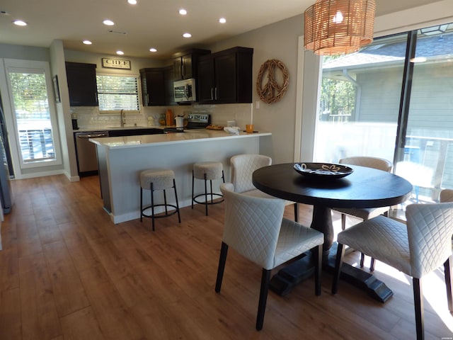 kitchen featuring stainless steel appliances, light countertops, a sink, and wood finished floors