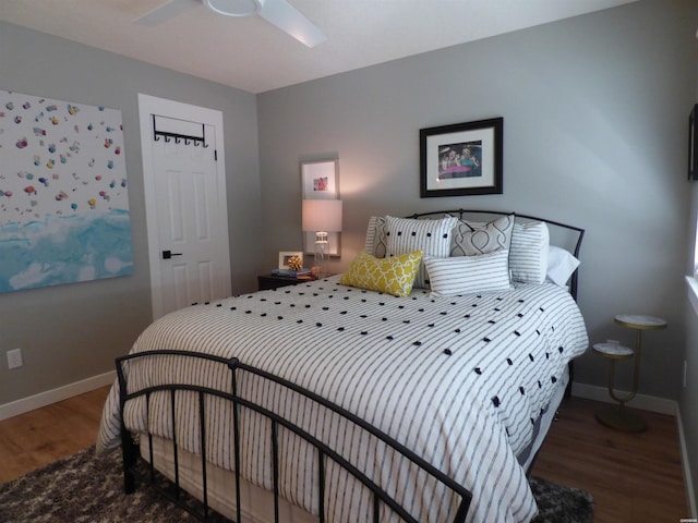 bedroom with dark wood-style floors, ceiling fan, and baseboards