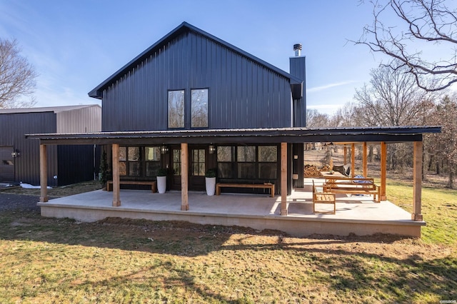 back of property featuring a patio area and a lawn