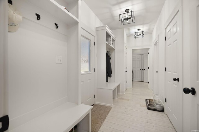 mudroom featuring light wood-style floors and a notable chandelier