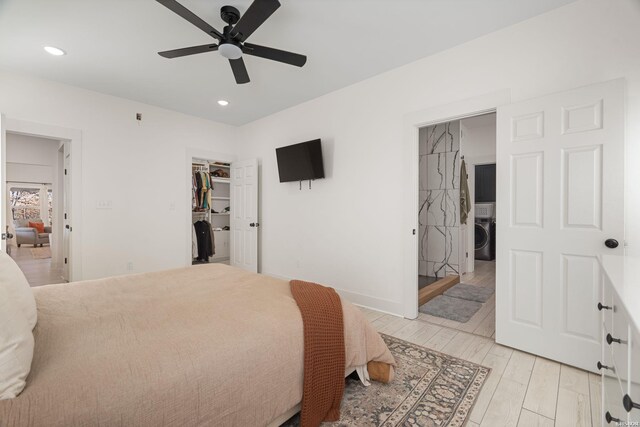 bedroom featuring light wood finished floors, washer / dryer, a walk in closet, a closet, and recessed lighting