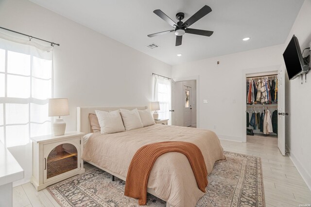 bedroom with a spacious closet, recessed lighting, visible vents, and baseboards