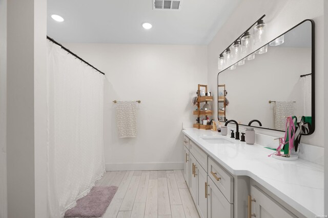 full bathroom featuring recessed lighting, visible vents, vanity, wood finished floors, and baseboards