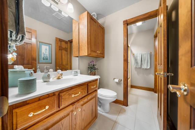 bathroom featuring visible vents, toilet, vanity, tile patterned flooring, and baseboards