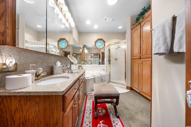 bathroom with vanity, backsplash, a shower stall, and visible vents