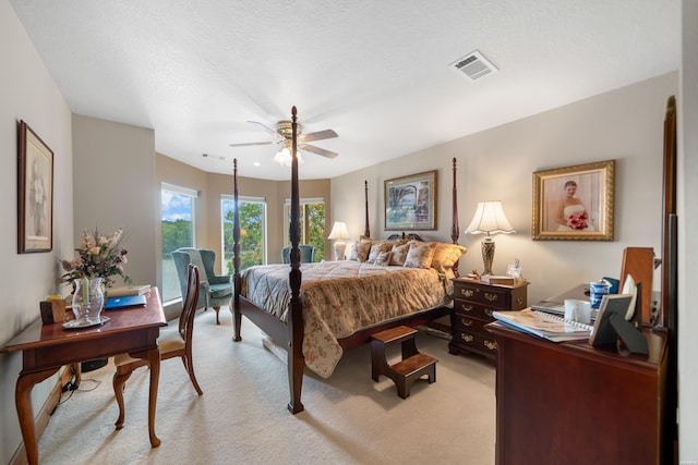 bedroom featuring light carpet, ceiling fan, visible vents, and a textured ceiling