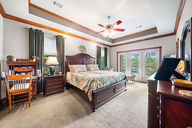 bedroom with a raised ceiling, visible vents, crown molding, and light carpet