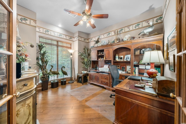 home office with ceiling fan, light wood-type flooring, and visible vents